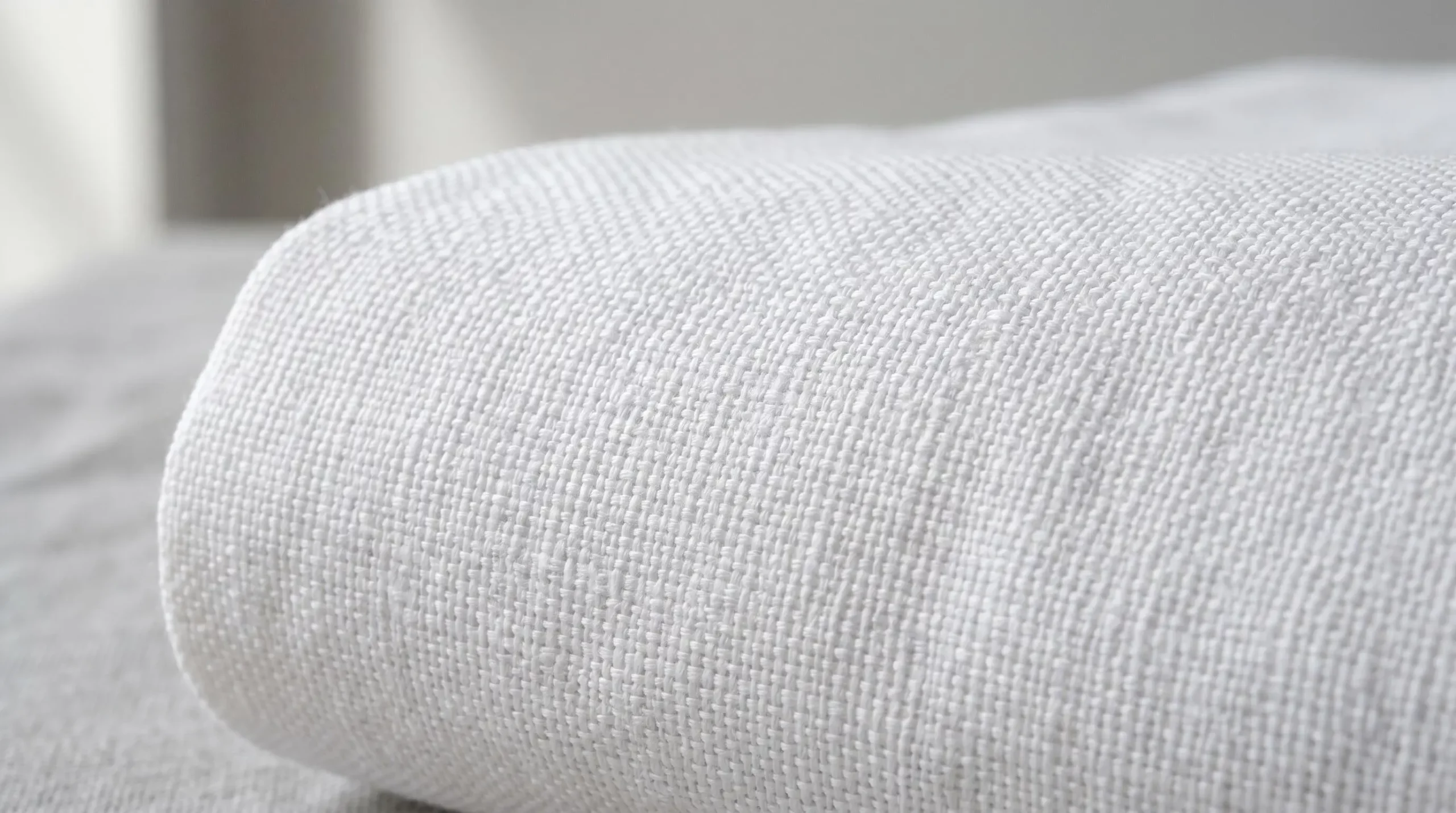 Gros plan sur la texture d'un tissu en coton percale au tissage serré, fils réguliers visibles, surface lisse et uniforme